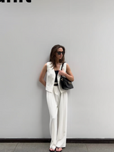 A lady wears a vest made of leather-like fabric